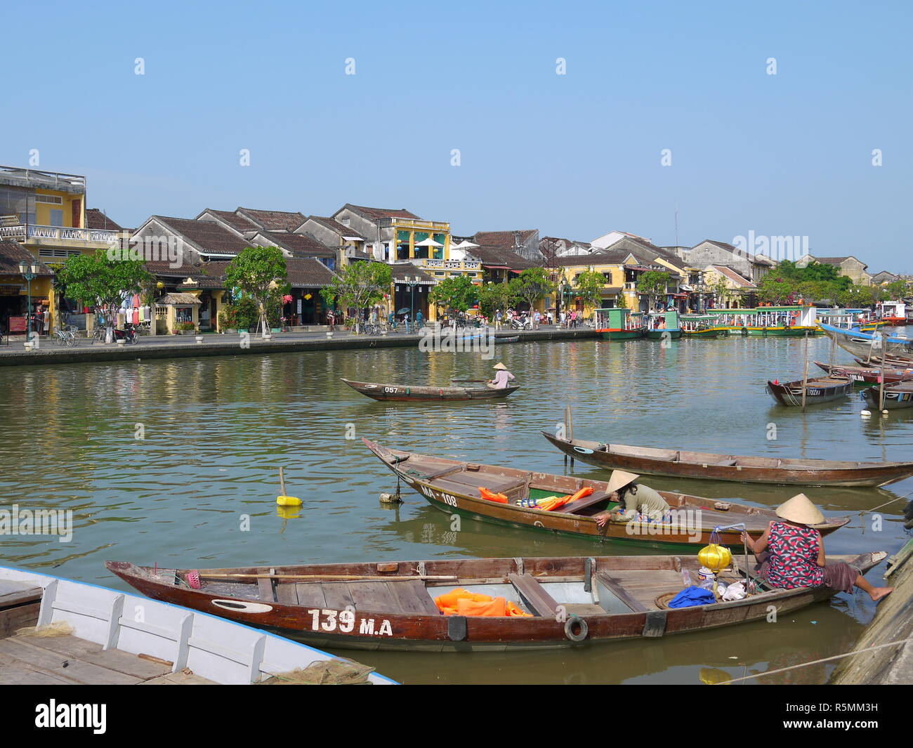HOI AN (Vietnam), VIETNAM - 19 mars 2018 : rivière occupé dans l'ancienne ville de Hoi An avec vue sur les bateaux traditionnels, les maisons et les touristes jaune Banque D'Images