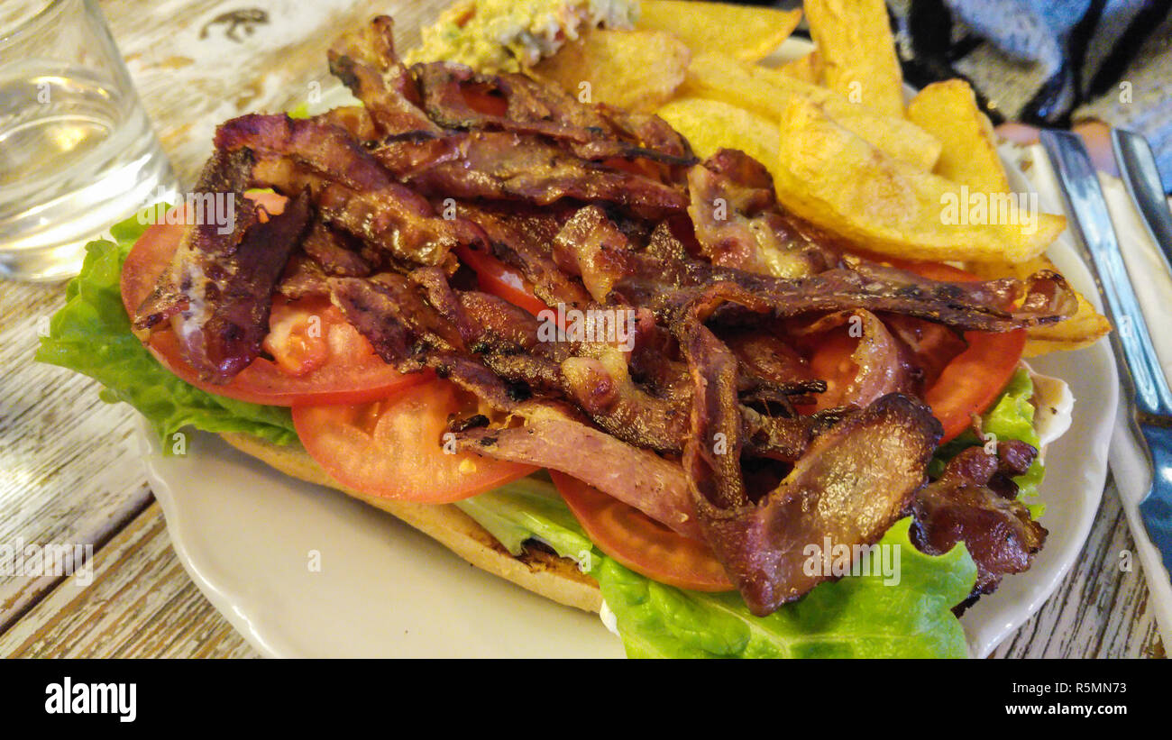 Menu Brunch plat composé de sandwich à la tomate et bacon letuce avec frites et le guacamole sur le côté. Banque D'Images