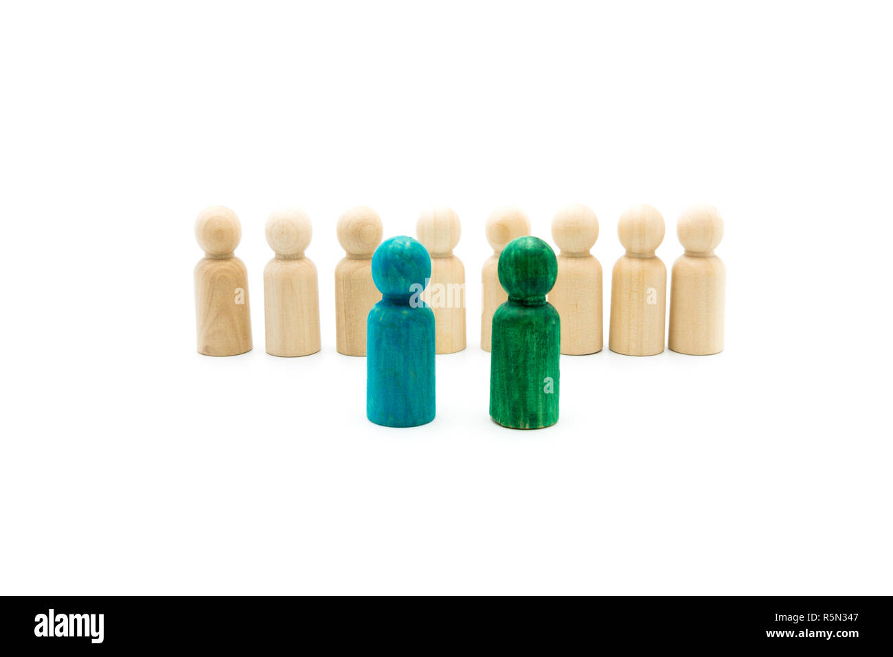 Figures en bois en ligne que l'équipe d'affaires, avec chiffres bleu et vert se démarquer de la foule, isolé sur fond blanc. Image conceptuelle de le Banque D'Images