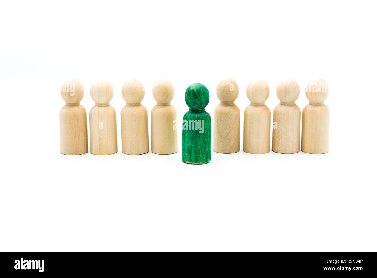 Figures en bois en ligne que l'équipe d'affaires, avec un vert figure debout de la foule, isolé sur fond blanc. Image conceptuelle d'être di Banque D'Images