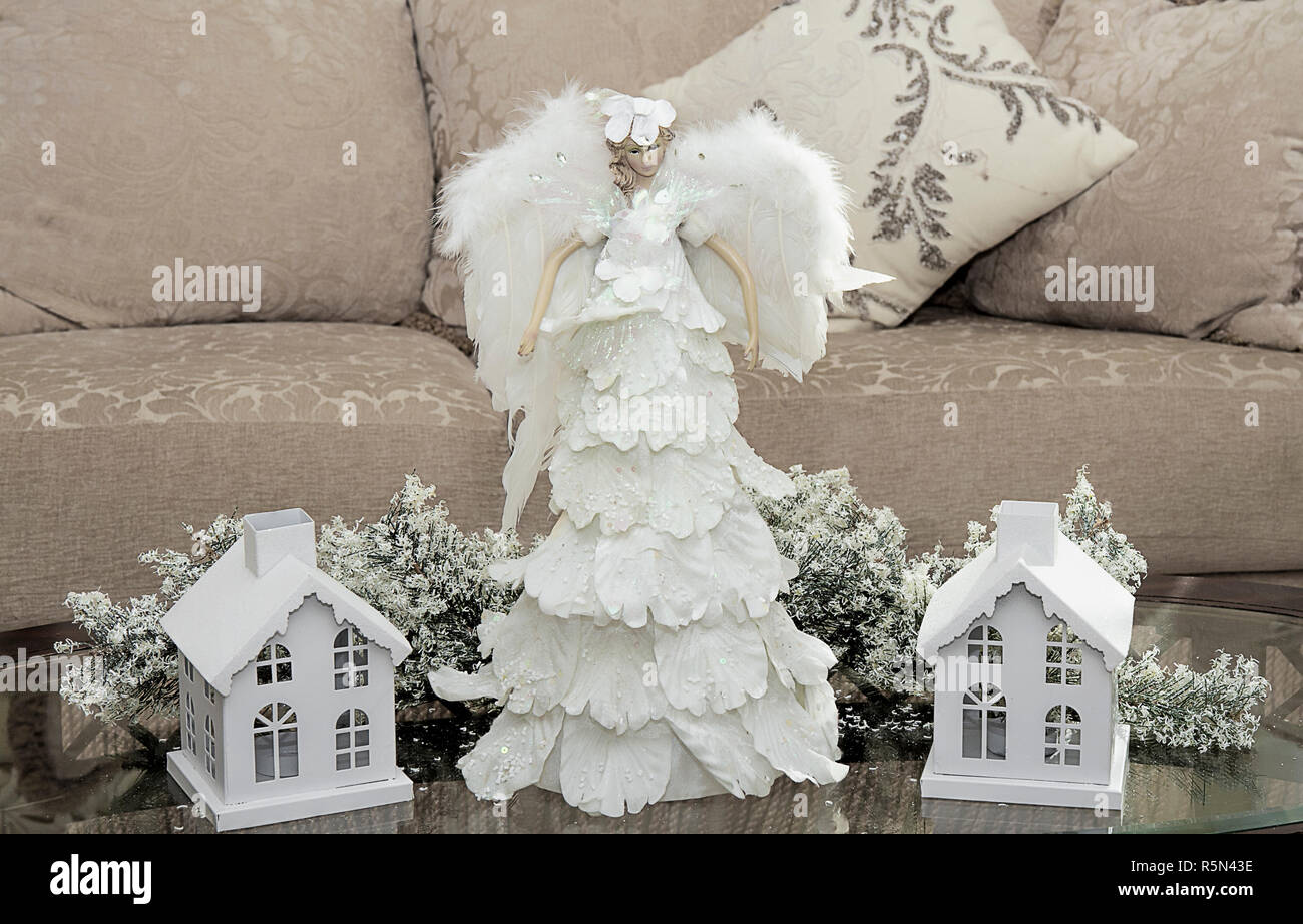 Ange décoration sur une table basse entourée de maisons couvertes de neige. Décoration de Noël Banque D'Images
