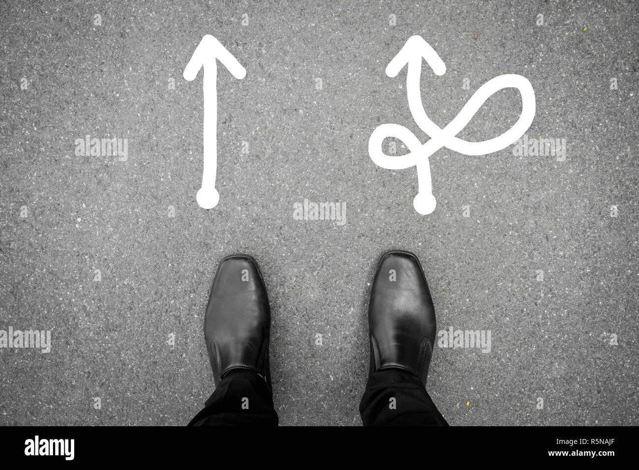 Chaussures noires debout à la croisée des chemins et doit prendre une décision où aller pour son succès - manière difficile ou facile Banque D'Images