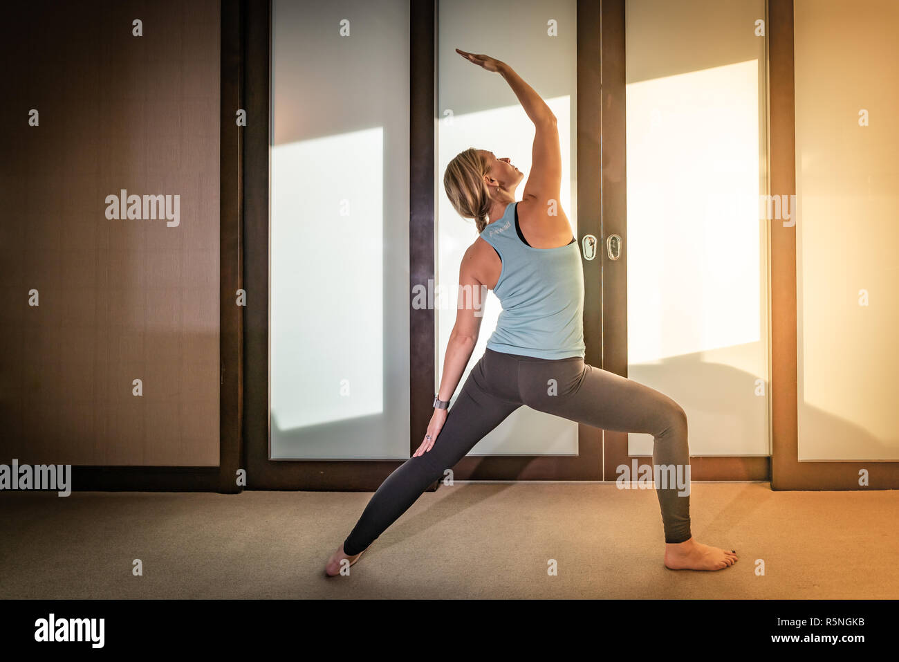 Woman doing yoga le matin lors d'un voyage et d'un séjour à l'hôtel Banque D'Images