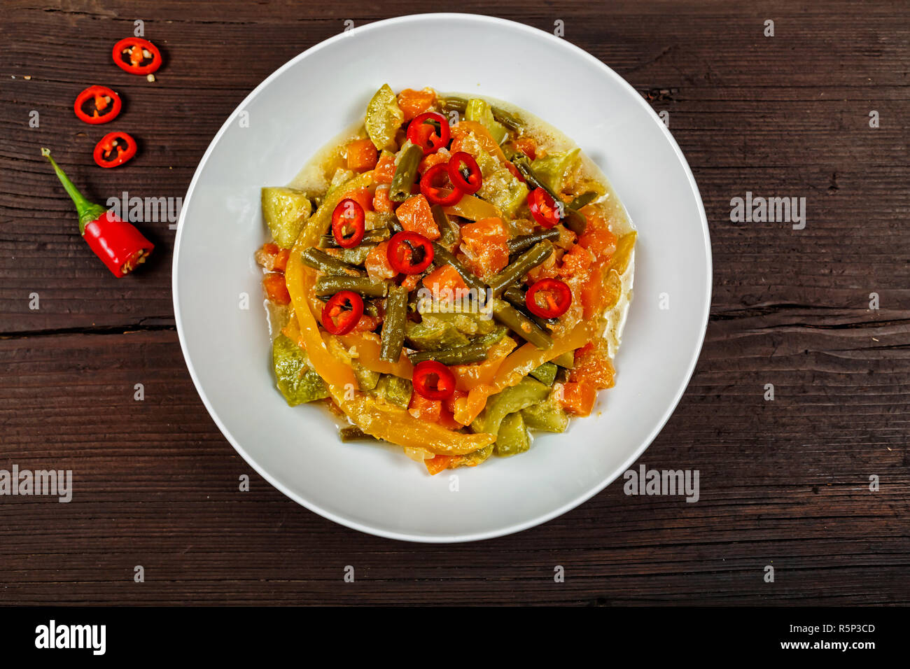 Légumes pan. Ragoût de légumes à la mexicaine appétissante avec le piment dans un plat blanc sur une table en bois. Vue d'en haut Banque D'Images