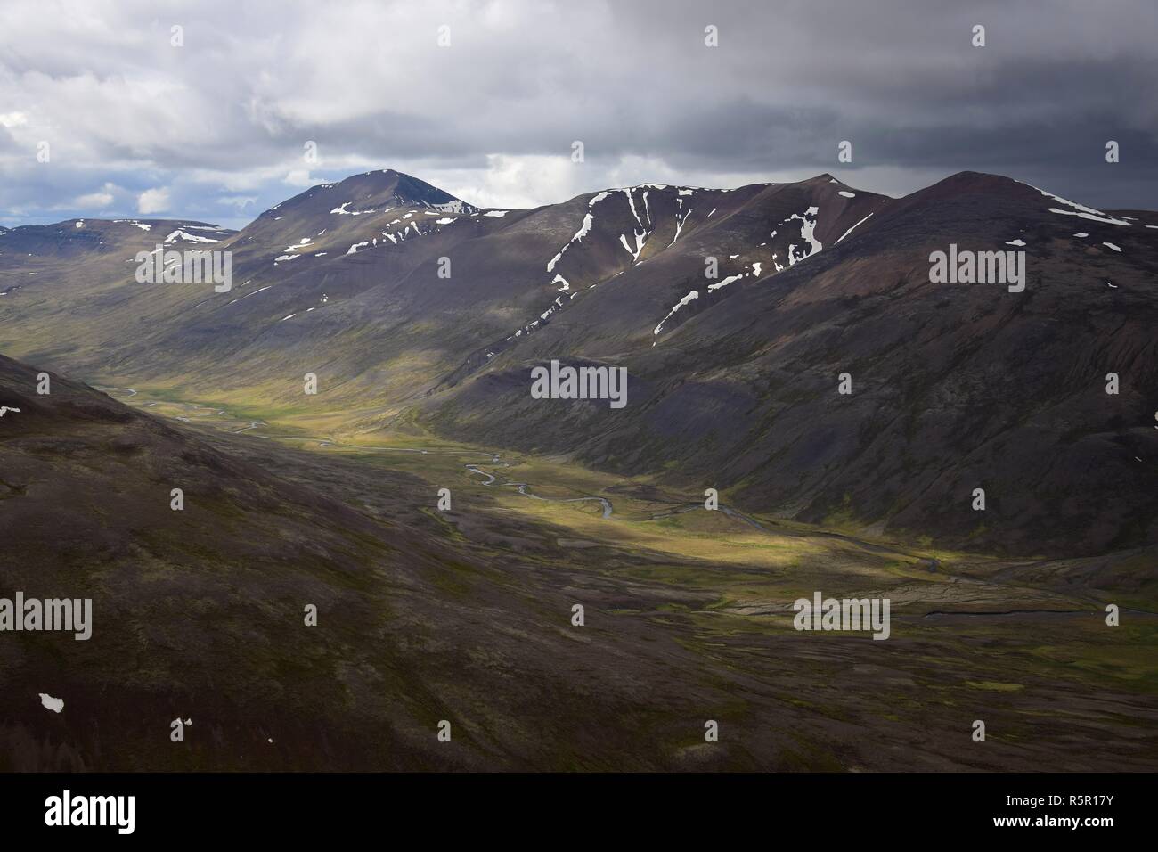 Paysage islandais. La vallée entre le Svinadalsfjall et l'Vatnsdalsfjall. Vue depuis le sommet d'une montagne. Pour la plupart, nuageux avec quelques taches de s Banque D'Images
