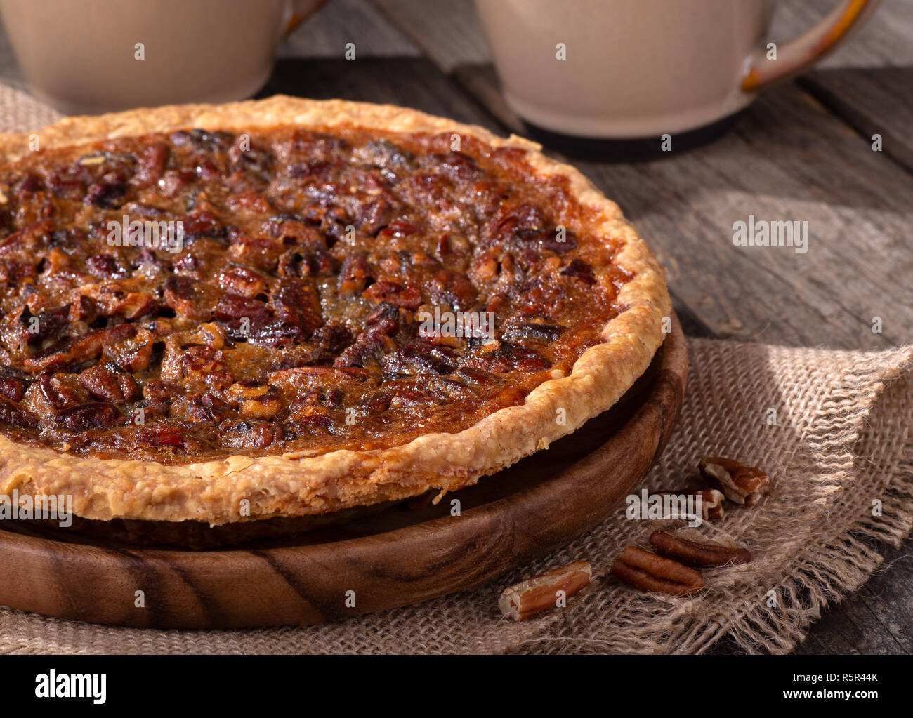 Libre d'un ensemble de la tarte aux pacanes avec les tasses de café en arrière-plan sur une surface en bois rustique Banque D'Images