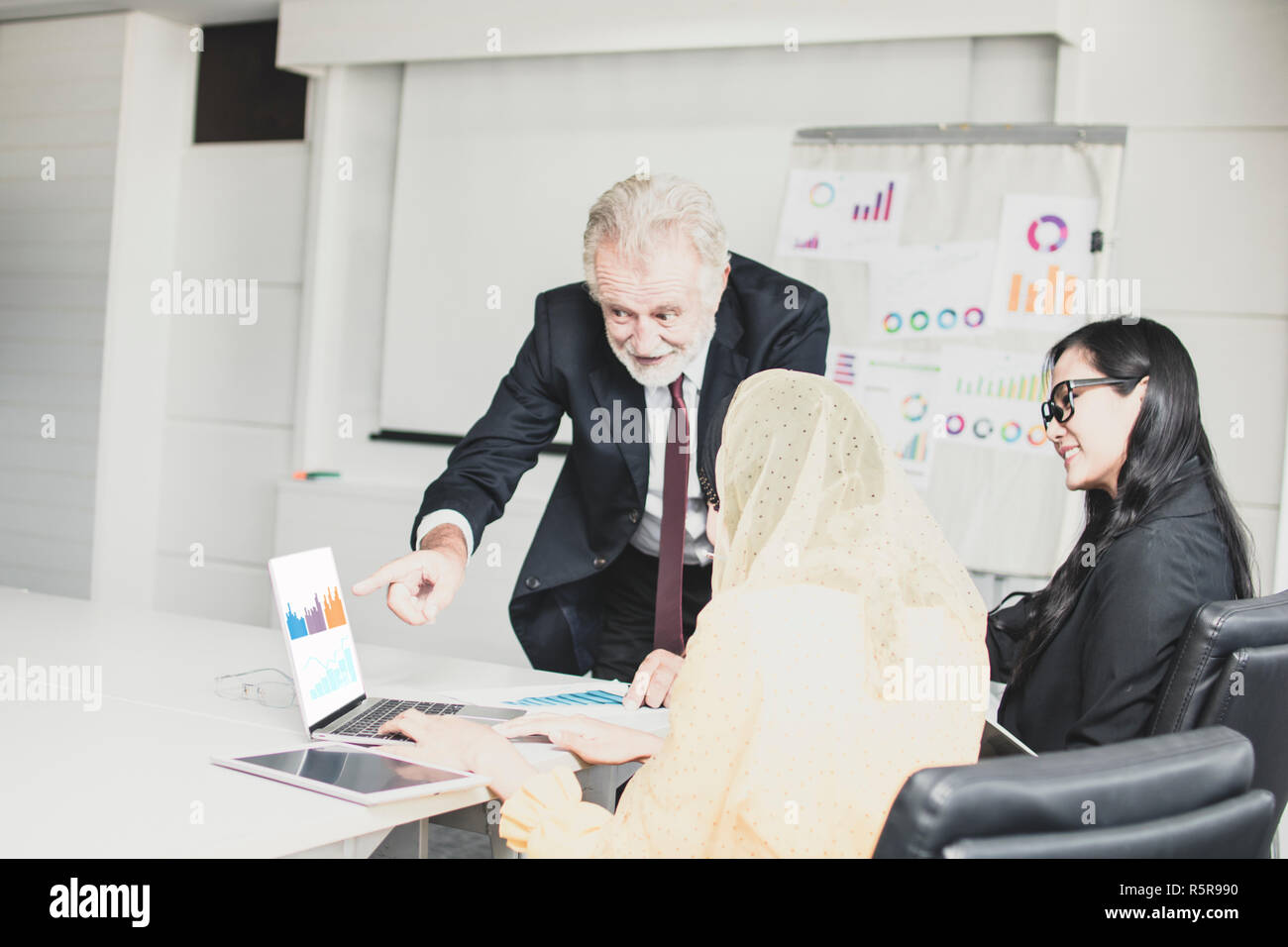 Big Boss, heureux ancien manager à la pointe et de travailler sur l'ordinateur portable de l'employé entre parler, rabotage et de brain storming comme répondant Banque D'Images