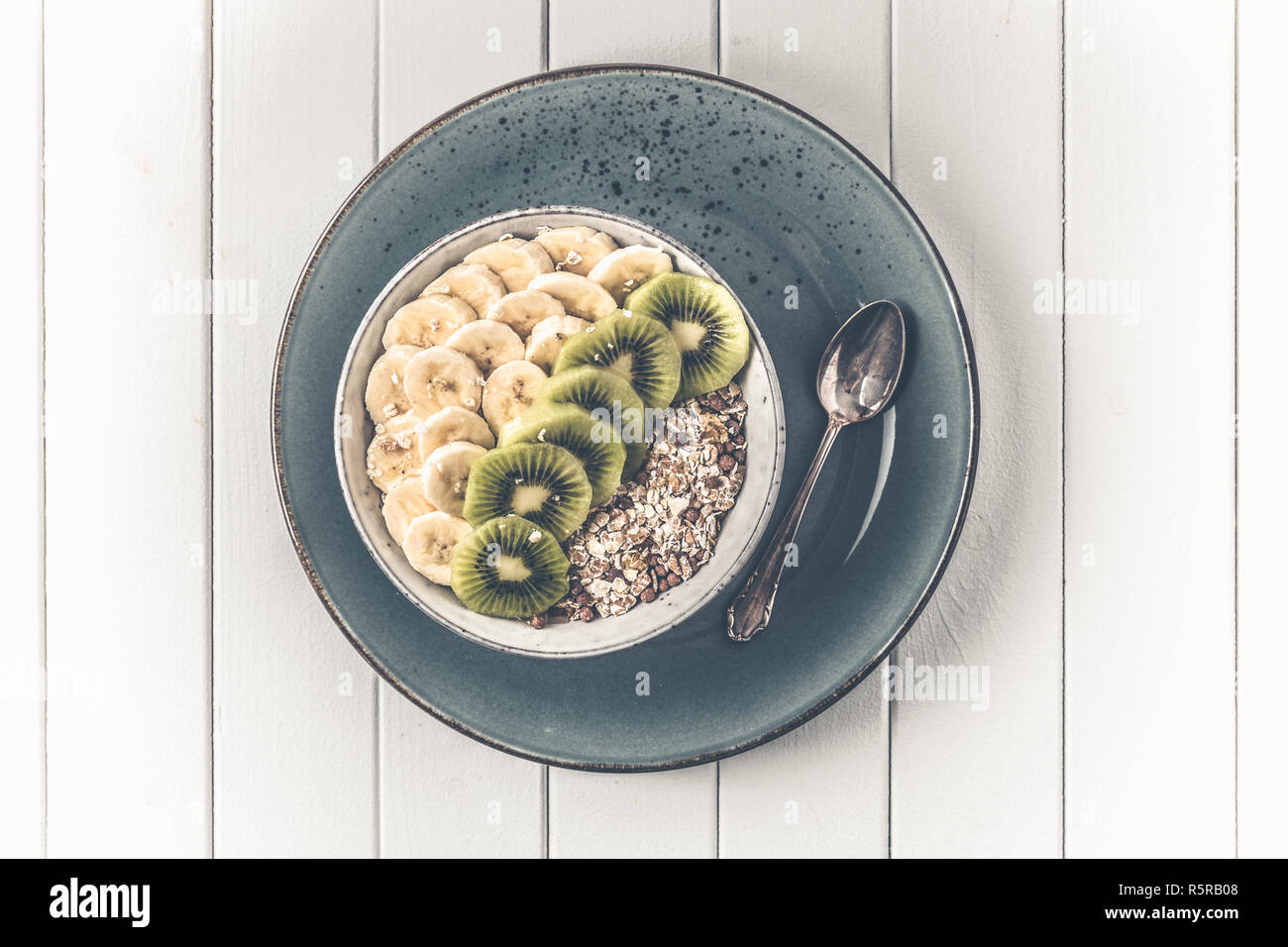 Petit-déjeuner sain dans un bol avec les kiwis et les bananes Banque D'Images