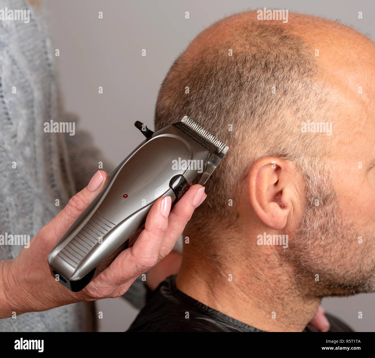 Tondeuses électriques portables étant utilisés pour donner un homme chauve  d'une coupe de cheveux style de cheveux Photo Stock - Alamy