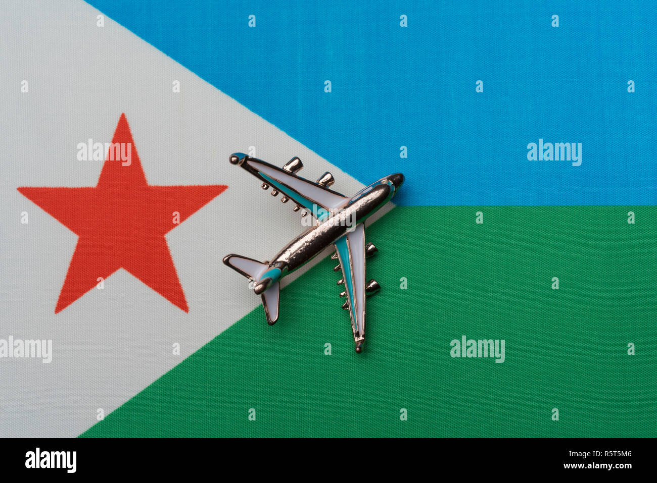 Plus d'avion Djibouti drapeau, travel concept. Toy airplane sur le drapeau comme arrière-plan. Banque D'Images