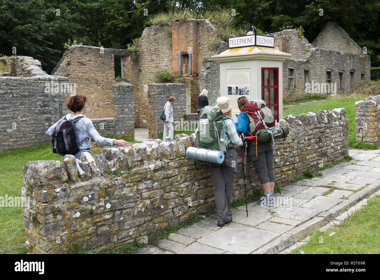 Backpackers explorant le célèbre 'village fantôme' de Tyneham, un village qui a été déserté en 1943 pour l'entraînement militaire sur l'île de Purbeck, Dorset Banque D'Images