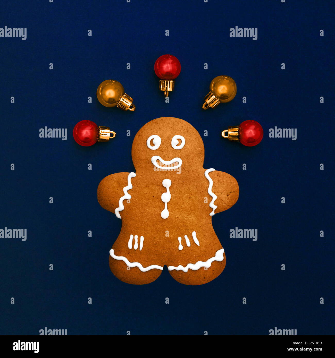 Christmas gingerbread cookie classique photo télévision jeter l'homme est couché sur un fond bleu foncé avec des boules de Noël vue supérieure Banque D'Images