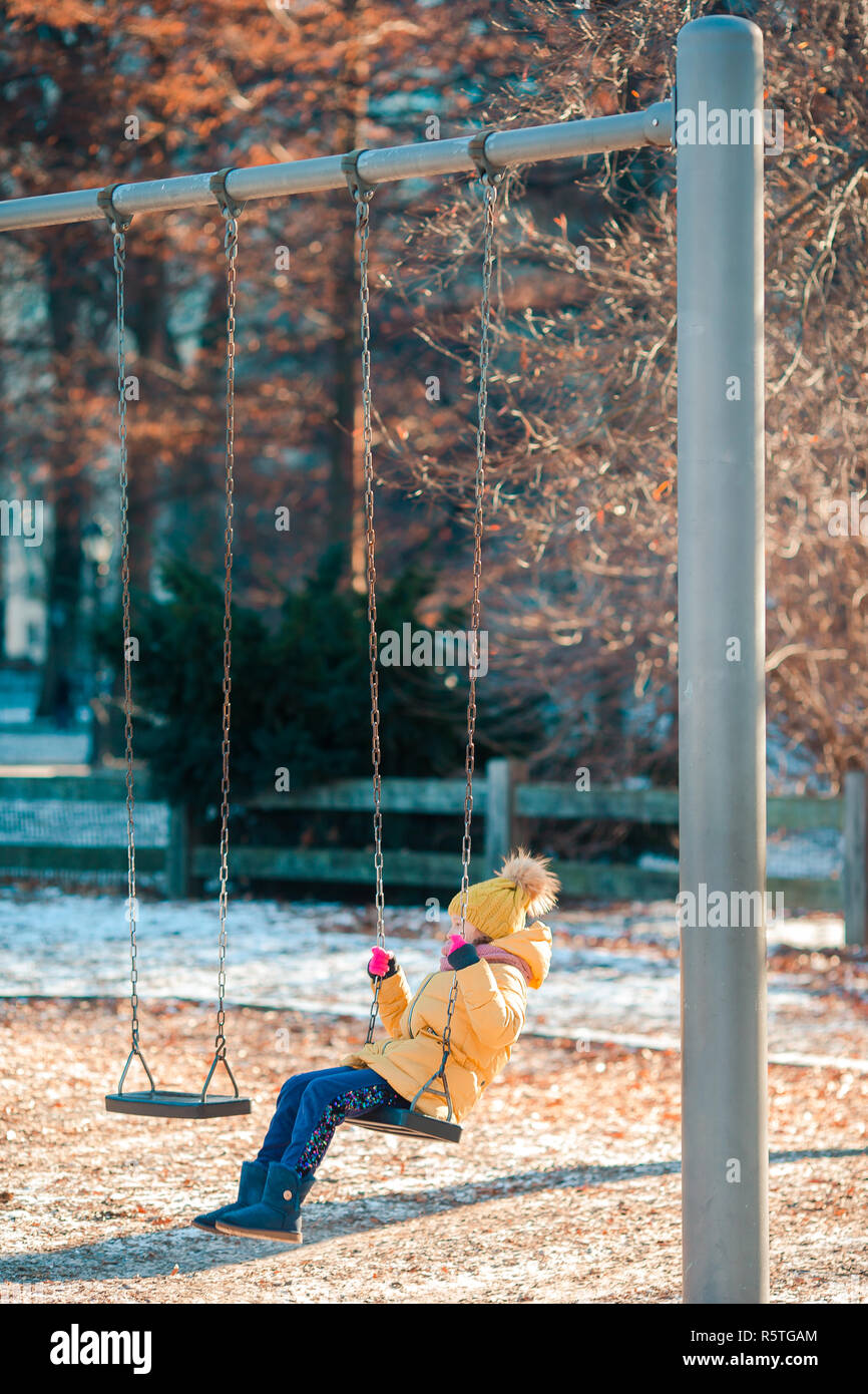 Adorable petite filles balançoires sur une balançoire dans Central Park à  New York City Photo Stock - Alamy
