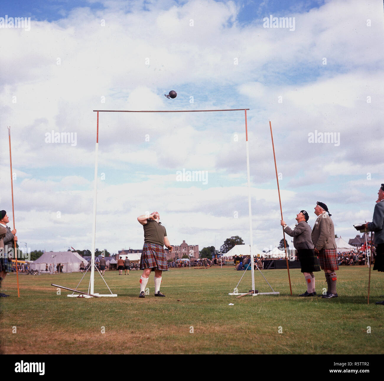 Années 1960, les jeux des Highlands, Ecosse, Royaume-Uni. L'image montre un concurrent et fonctionnaires au-dessus du bar 'poids', événement qui implique l'athlète jetant une 56-pund (4-stone) poids avec poignée ci-joint sur une barre horizontale à l'aide d'une seule main. La réussite d'écartement comme vu ici permet au concurrent d'avance à la prochaine série à une plus grande hauteur. Banque D'Images