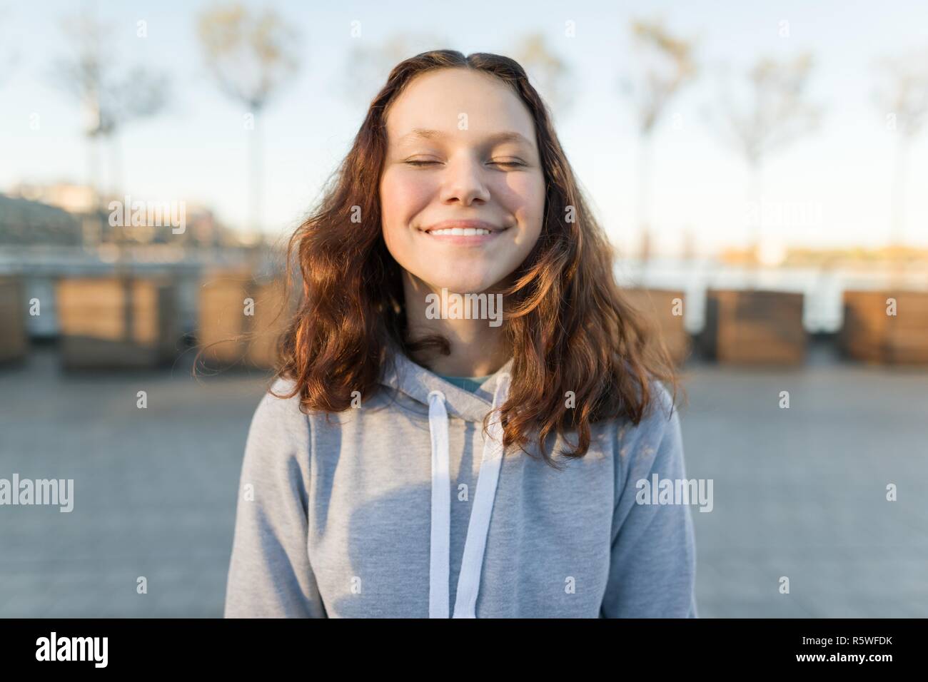Portrait of a happy girl avec les yeux fermés, heure d'or Banque D'Images