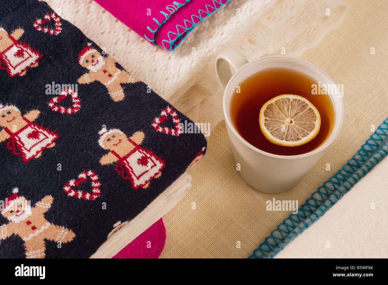 Noël arrière-plan des vêtements d'hiver avec les schémas traditionnels, du thé chaud avec du citron. Banque D'Images