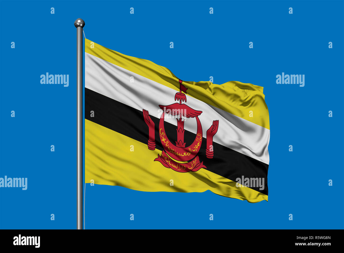 Pavillon de Brunei forme dans le vent contre ciel bleu profond. Drapeau brunéien. Banque D'Images