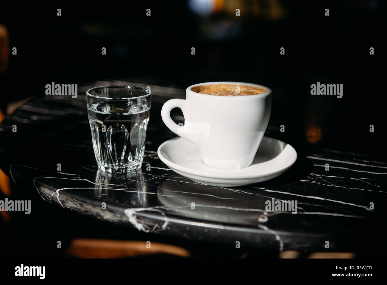 Close-up d'une tasse de café et le verre d'eau sur une table Banque D'Images