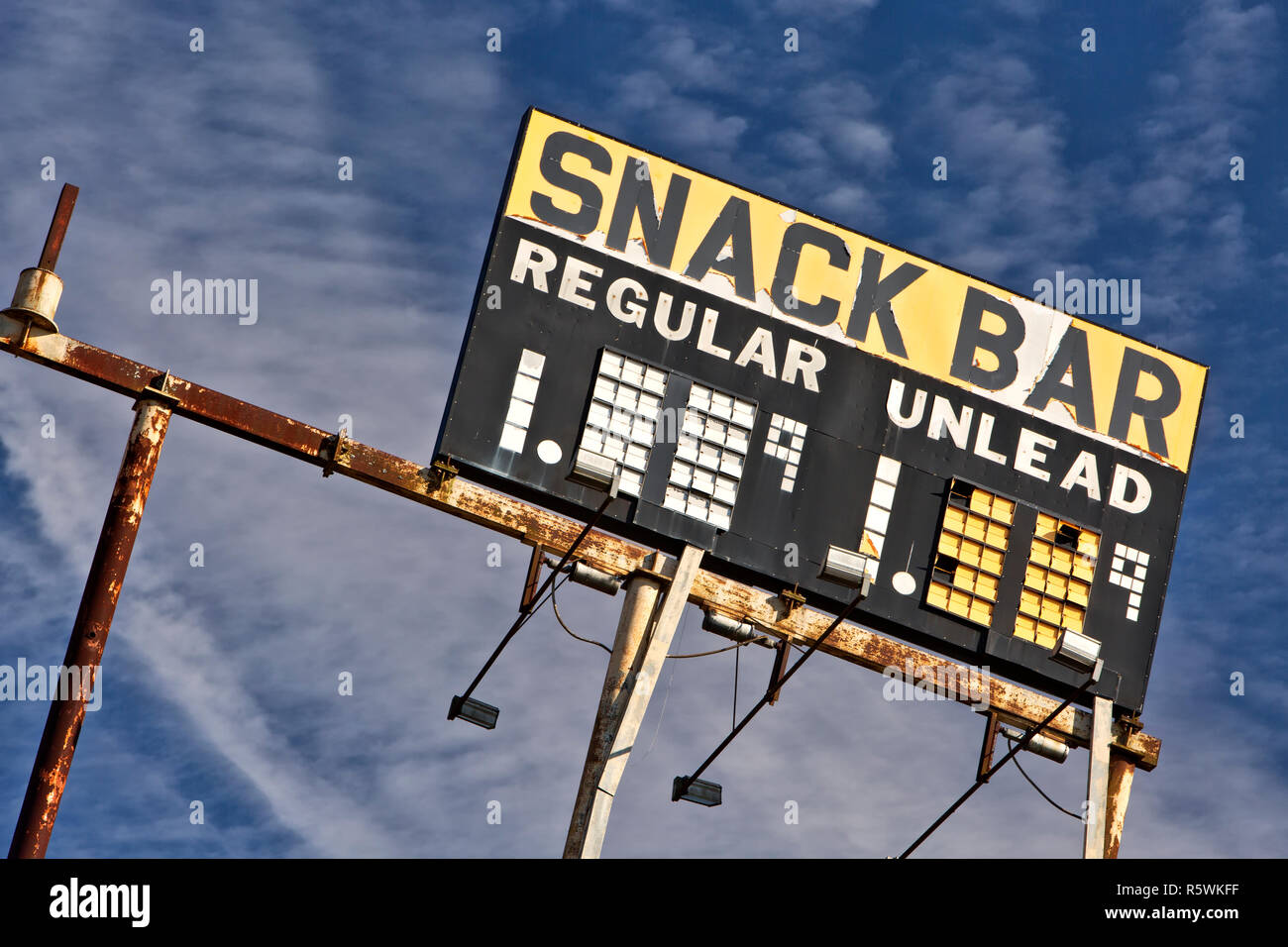 Station Vintage élevé signe 'Snack Bar - Régulier & Unlead' essence, contre un ciel bleu. Banque D'Images Station Vintage élevé signe 'Snack Bar - Régulier & Unlead' essence, contre un ciel bleu. Banque D'Images