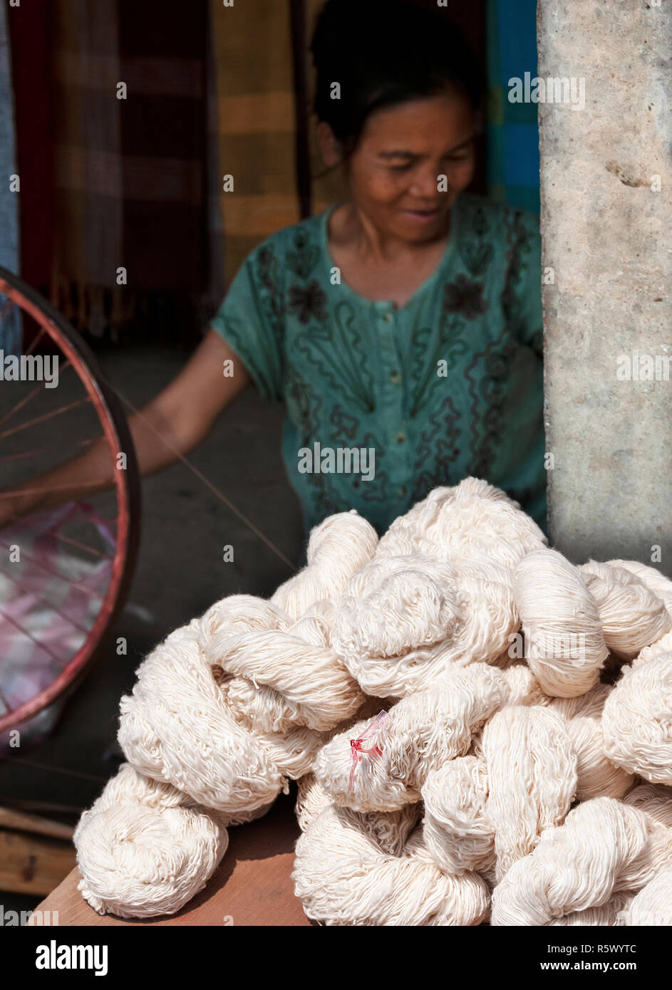 Femme laotienne filage de la laine en fil qui elle est enveloppé dans des méandres appelés écheveaux qui sont prêts à tricoter de près de Luang Prabang, Laos, République Banque D'Images