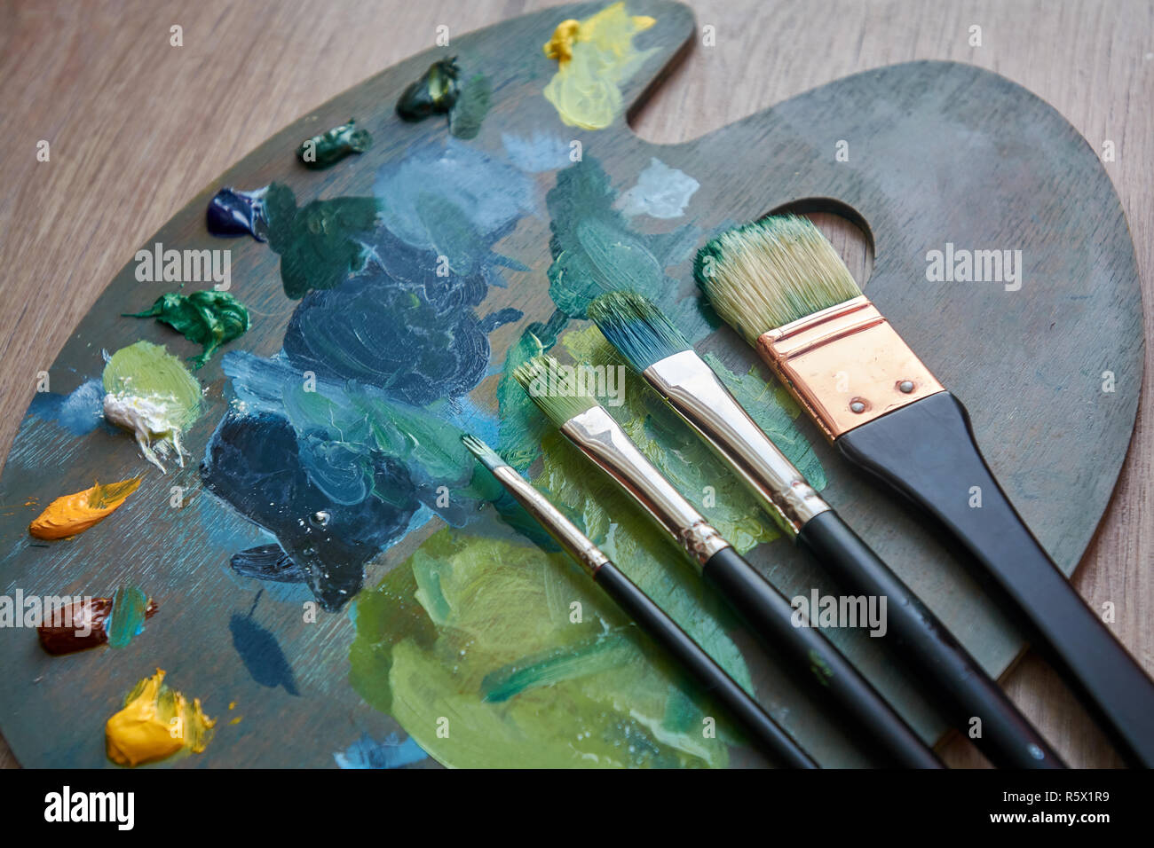 La palette de l'artiste avec des peintures à l'huile et les pinceaux sur un fond de bois. Peinture Hobby concept. Banque D'Images