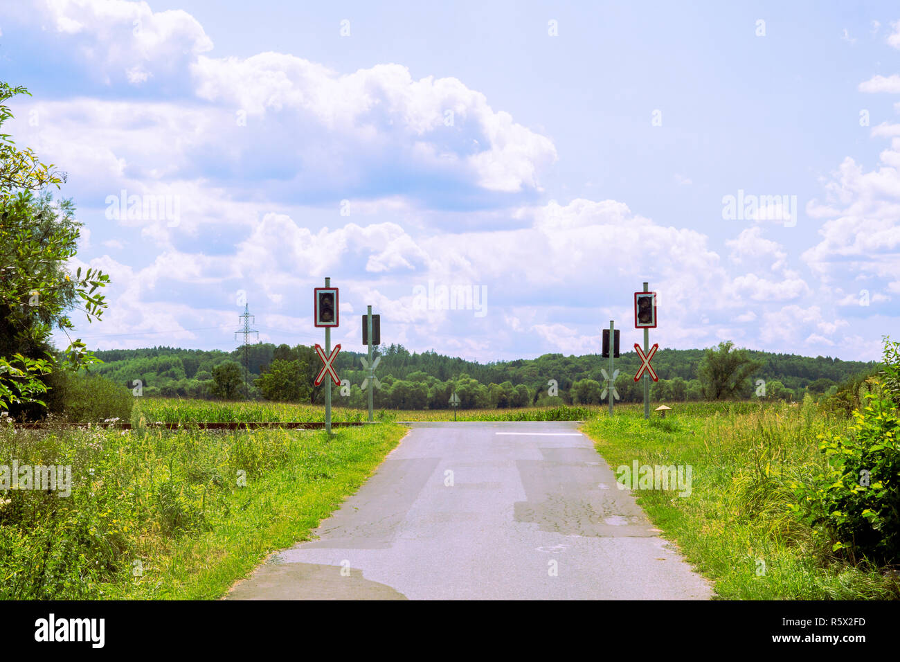 Rural vide de passage à niveau sans barrières, passage à niveau, voir avec ciel bleu et nuages, campagne. Croix de Saint André et de feux de circulation. Banque D'Images