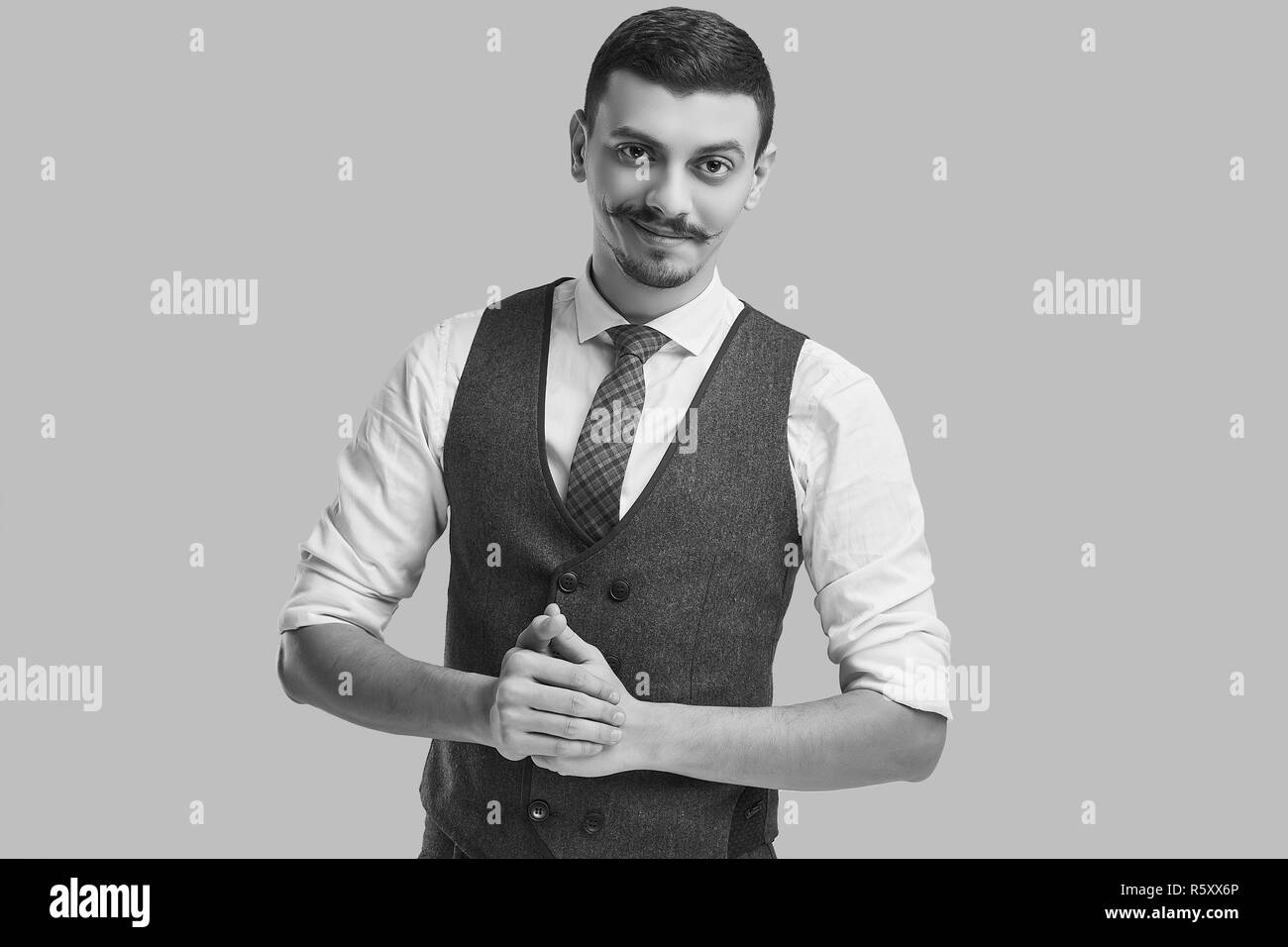 Portrait de beau jeune homme arabe confiant avec fantaisie moustache en costume marron en laine sur fond de studio Banque D'Images