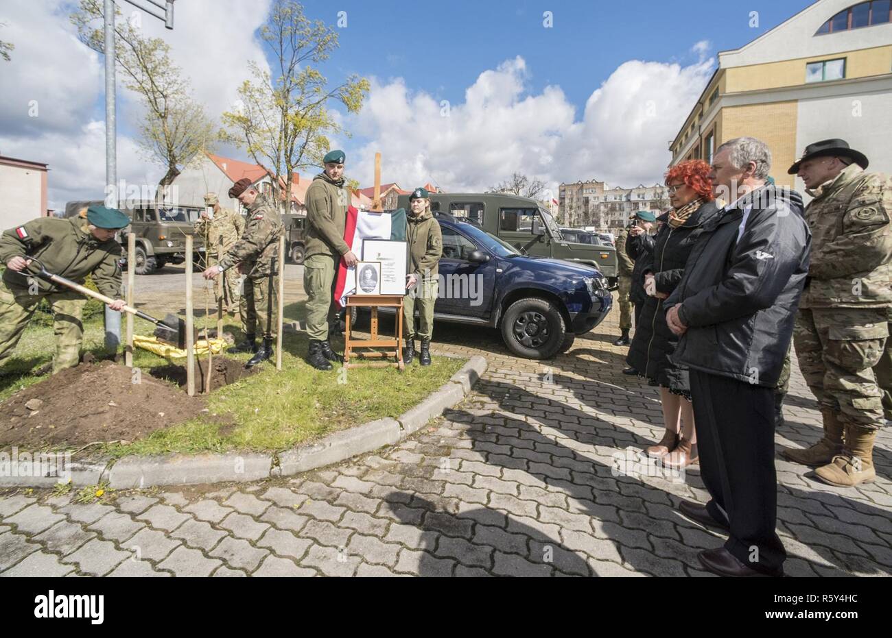 Un Mundurowej Centrum Edukacji plantes étudiant un chêne au cours d'une cérémonie en l'honneur Henryk Bartoszewicz, un officier de cavalerie polonaise assassinés durant le massacre de Katyn en 1940. L'académie militaire local à Elk, Pologne, a invité le groupe de combat du lieutenant-colonel commandant Pologne Steven Gventer (à droite) et ses soldats pour afficher leur équipement de combat et de petit calibre ainsi que l'armée polonaise, la 15ème Brigade Mécanisée de l'exposition statique lors de sa journée portes ouvertes annuelle le 22 avril. Banque D'Images
