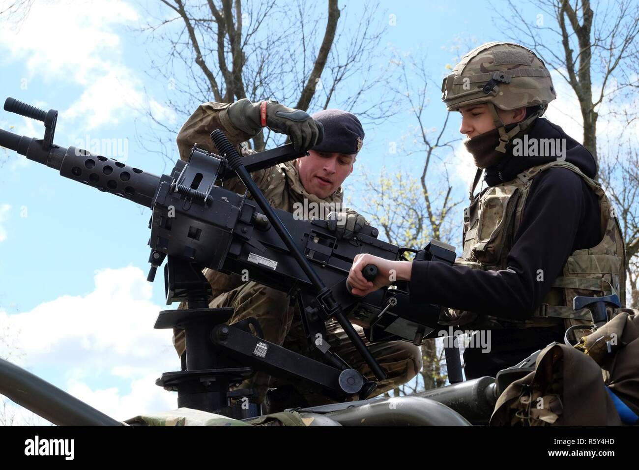 Burkinell privé britannique Dan, un groupe de combat Pologne soldat, montre un visiteur comment faire fonctionner la machine gun sur le dessus de la Jackal Véhicule blindé léger lors d'une exposition statique à une académie militaire à Elk, Pologne, le 22 avril. Pologne Groupe de combat et les armes de combat de l'équipement a été présenté avec une exposition statique à partir de la 15e Brigade mécanisée. Banque D'Images