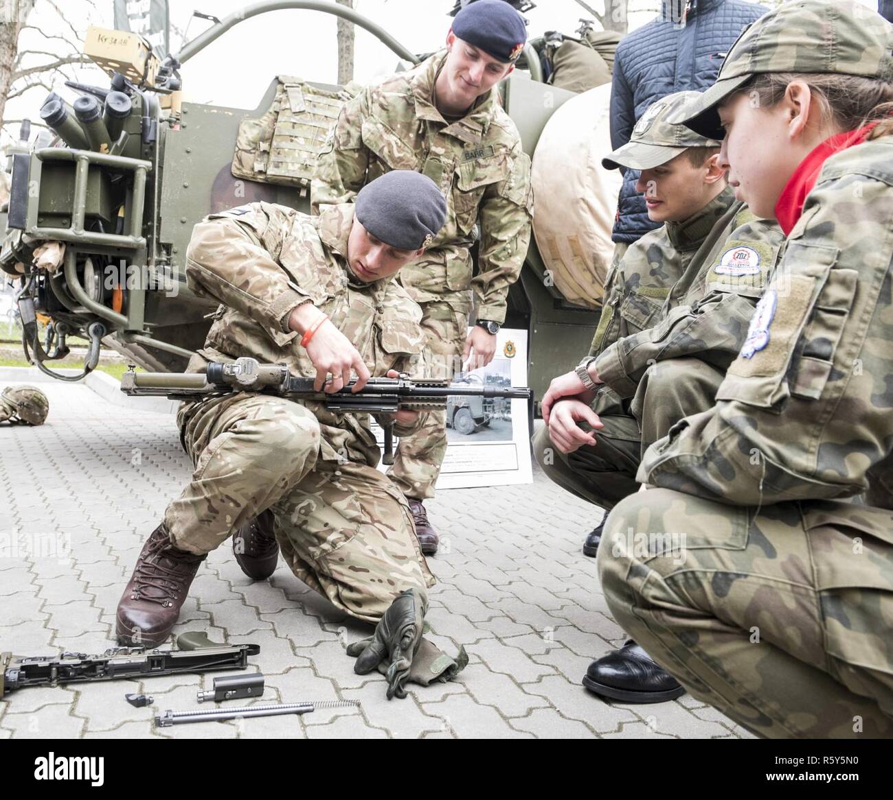 Un soldat britannique de Battle Group Pologne brise son fusil d'assaut pour les étudiants au cours de Journée Portes Ouvertes à l'Stol DOSKONALENIA ZAWODOWEGO, une école militaire, à Gizycko, Pologne 25 avril. Au cours de l'événement, les étudiants et les citoyens polonais ont interagi avec l'unité multinationale et exploré son équipement de combat. L'unique formation d'américains, britanniques et soldats roumains sont en service avec Polish 15e Brigade mécanisée de soldats comme une force de dissuasion dans le nord-est de la Pologne à l'appui de l'OTAN vers l'amélioration de la présence. Banque D'Images