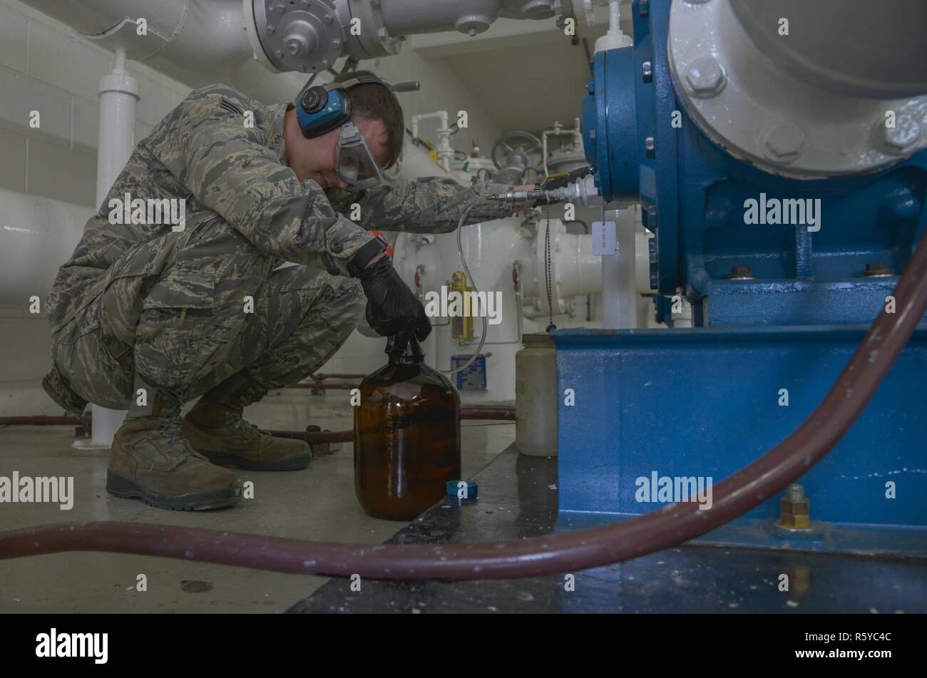 Le s.. David Carson, 374e Escadron de préparation logistique fossiles sous-officier responsable de laboratoire, remplit un récipient avec un échantillon d'cumulatifs JP8 à partir de 12 wagons-citernes de carburant à Yokota Air Base, Japon, le 19 avril 2017. Le laboratoire assure le carburant est propre, n'est pas mélangé avec d'autres types de carburant et répond aux normes militaires les met dehors. Banque D'Images