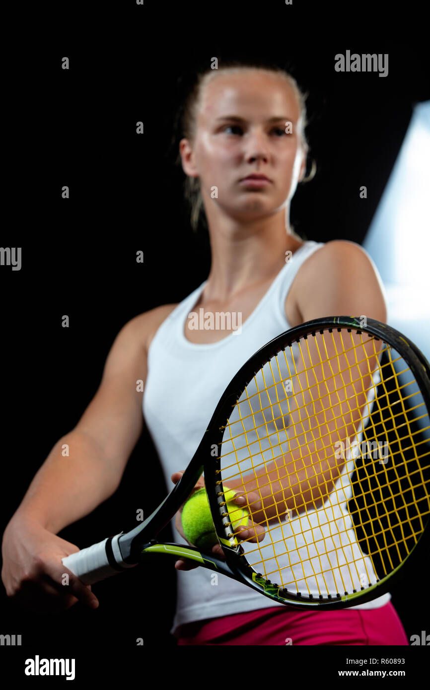 Portrait de femme belle à jouer au tennis à l'intérieur. Isolé sur le noir  Photo Stock - Alamy