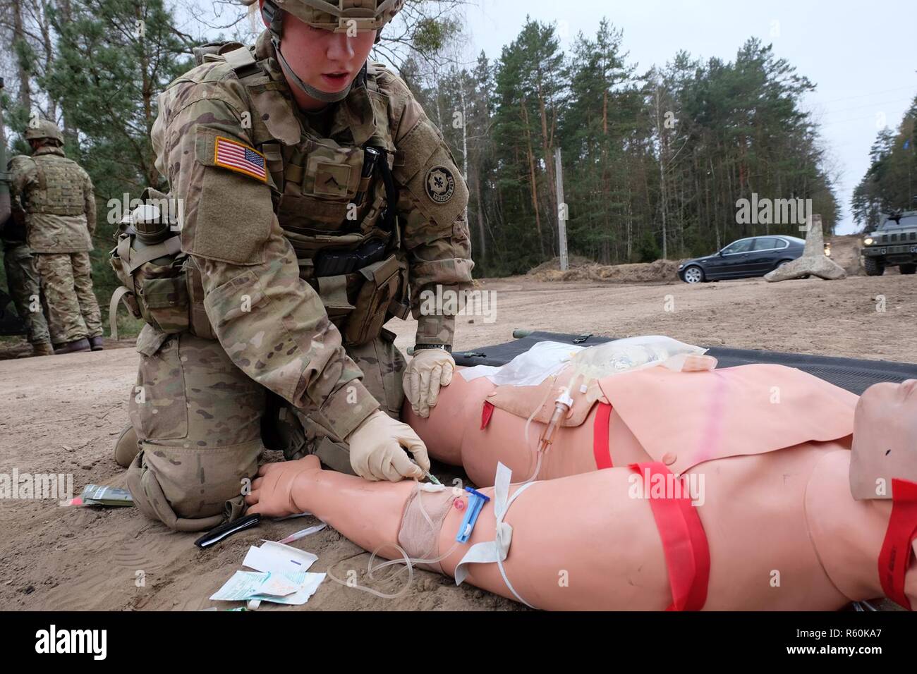 Pvt. Haley Hineman, Battle Group Pologne medic, donne un blessé un IV au cours de la formation en intervention d'urgence près de Bemowo Piskie 21 avril. Les exercices de répétition de la bataille de l'aide du personnel médical de Groupe d'identifier et de réduire les temps de garde et de transport des blessés. Banque D'Images