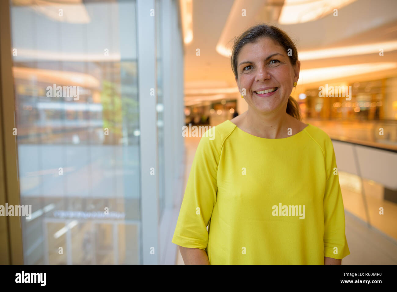 Portrait of happy young woman smiling inside shopping mall Banque D'Images