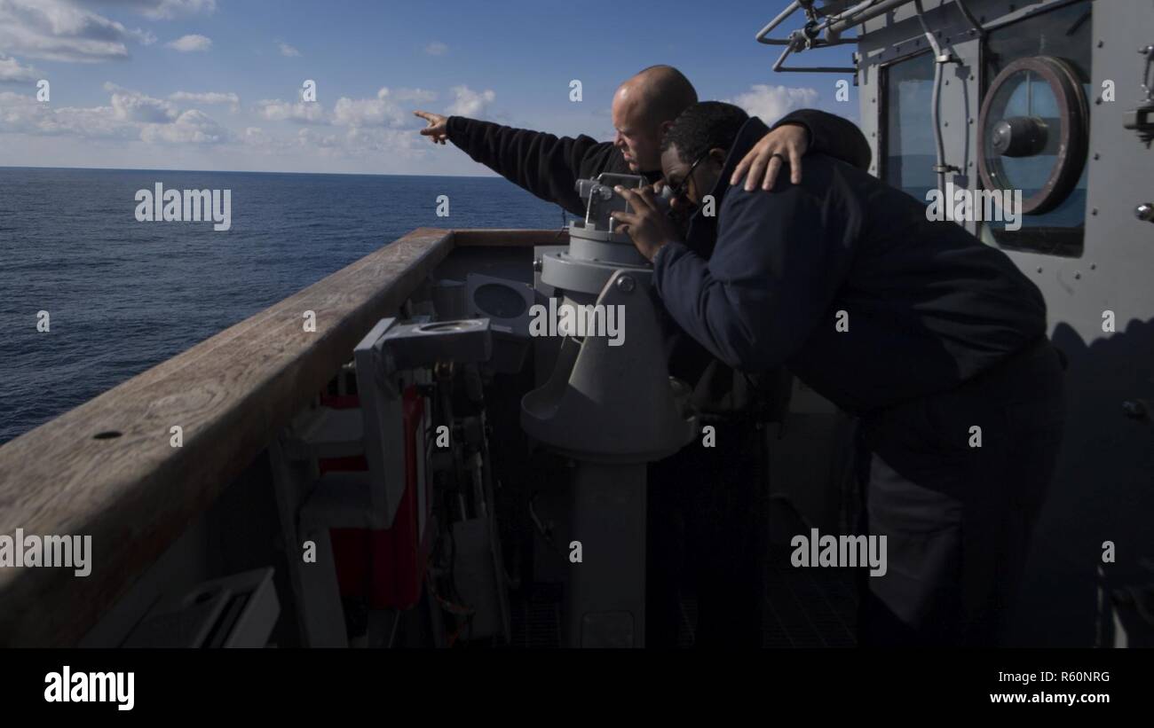 Mer du Nord (27 avril 2017) Maître de Manœuvre 3 Classe Kyle Molinaris Matelot Malik Ball montre comment utiliser une boussole alidade de classe Ticonderoga à bord du croiseur lance-missiles USS Leyte Gulf (CG 55). Le navire effectue des opérations navales dans la sixième flotte américaine zone d'opérations à l'appui de la sécurité nationale des États-Unis en Europe. Banque D'Images