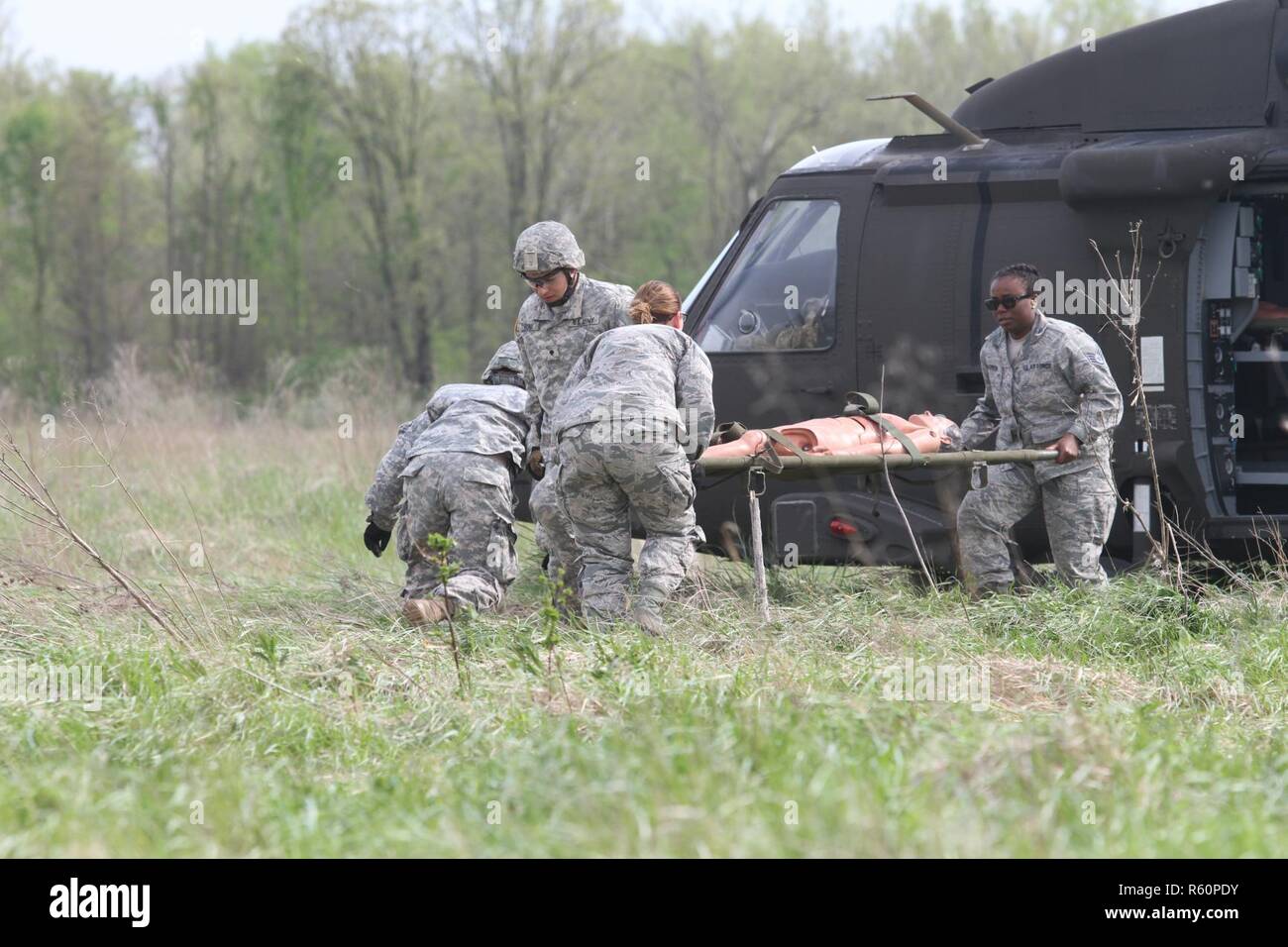 Réserve de l'armée de la CPS. Ryan Flores et de la CPS. Bailey de la Jungmann 469e Compagnie médicale, Wichita, Kansas de faire équipe avec le sergent de l'Armée de l'air. Cherrelle Warren et d'un membre de la 1re classe de l'Heldreth Echo 779ème Groupe médical, la Base Aérienne Macdill, Tampa, Floride rush pour transporter un mannequin patient d'un UH-60 Black Hawk au camp de soutien des intervenants (RSC), Engoulevent d'Indiana au cours d'un tuteur 17 Réponse Le 29 avril 2017. Près de 5 000 soldats et aviateurs canadiens de partout au pays participent à l'intervention d'un tuteur 17, un exercice d'entraînement multi-composants pour valider la capacité des militaires Banque D'Images