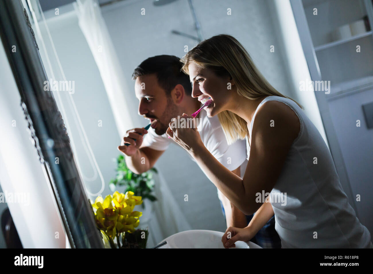 Happy young couple se brosser les dents dans la salle de bains Banque D'Images
