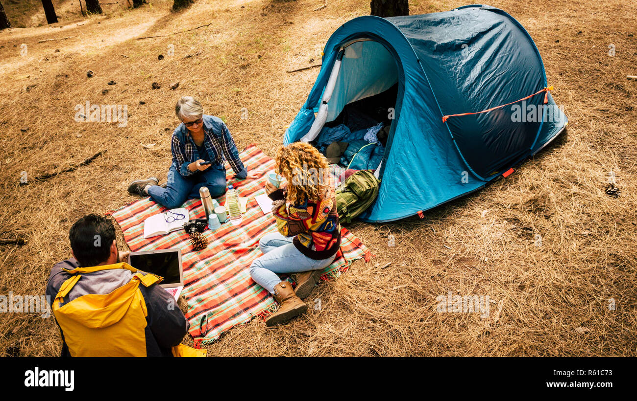 Les gens profiter de camping gratuit dans la forêt de pins à l'aide de la technologie mobile et portable fremeaux 3 400 et détendue de la société stress - vie de plein air pour al Banque D'Images