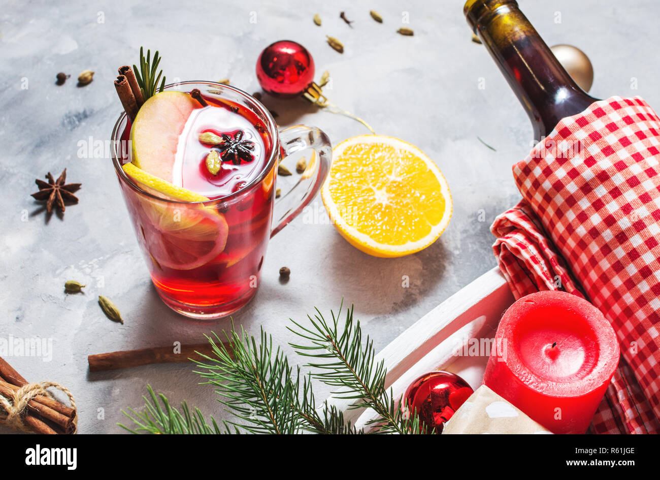 Vin chaud, une bouteille de vin rouge, branches d'épinette, de la cannelle, d'orange et de citron sur fond de béton. Boissons d'hiver. La veille de Noël Banque D'Images