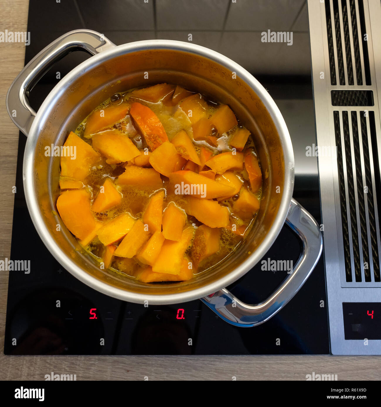 Citrouille dans la casserole de cuisson sur la cuisinière avec hotte Banque D'Images