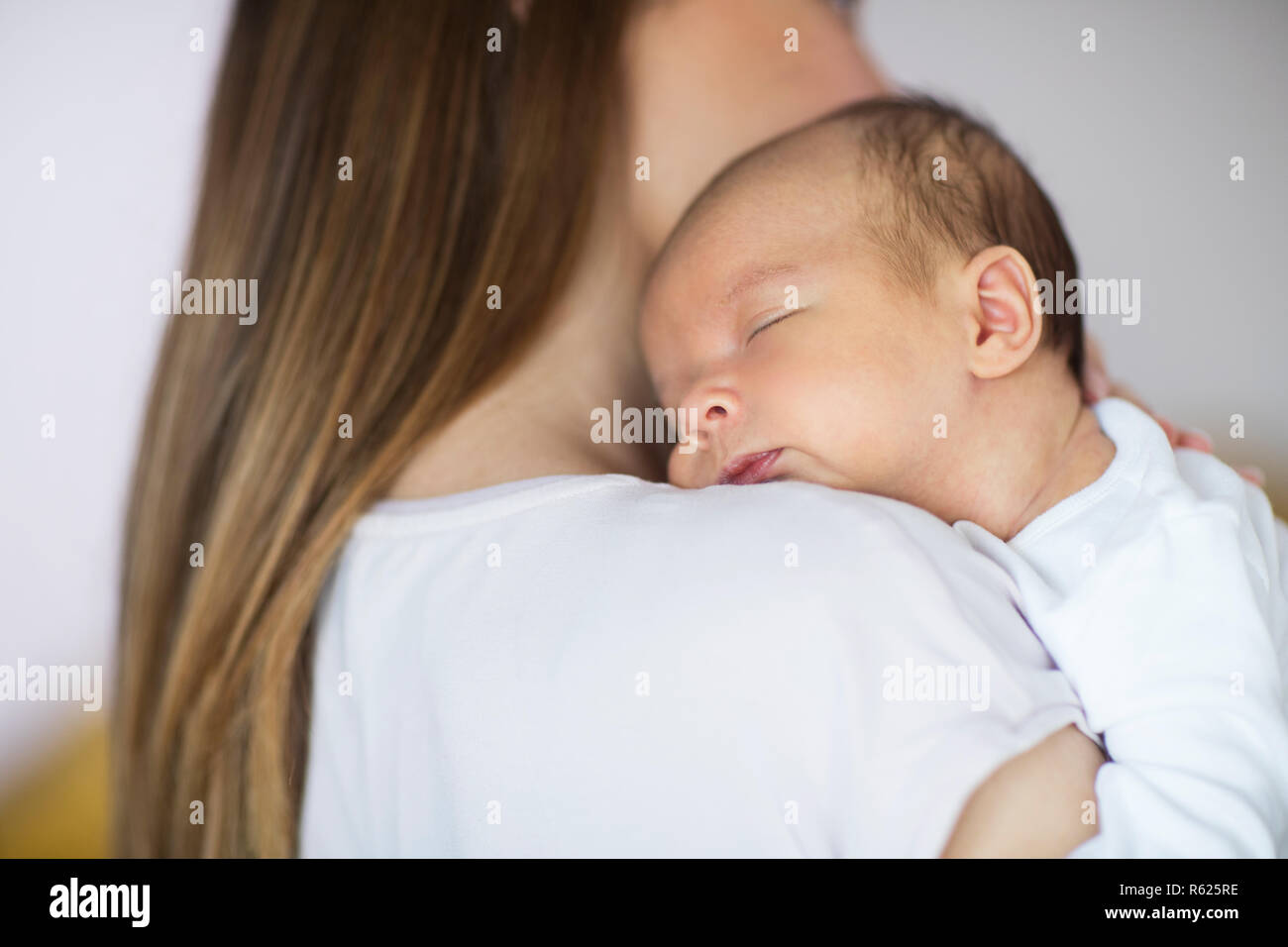 Mère de câlins dormir bébé nouveau-né fils over Shoulder Banque D'Images