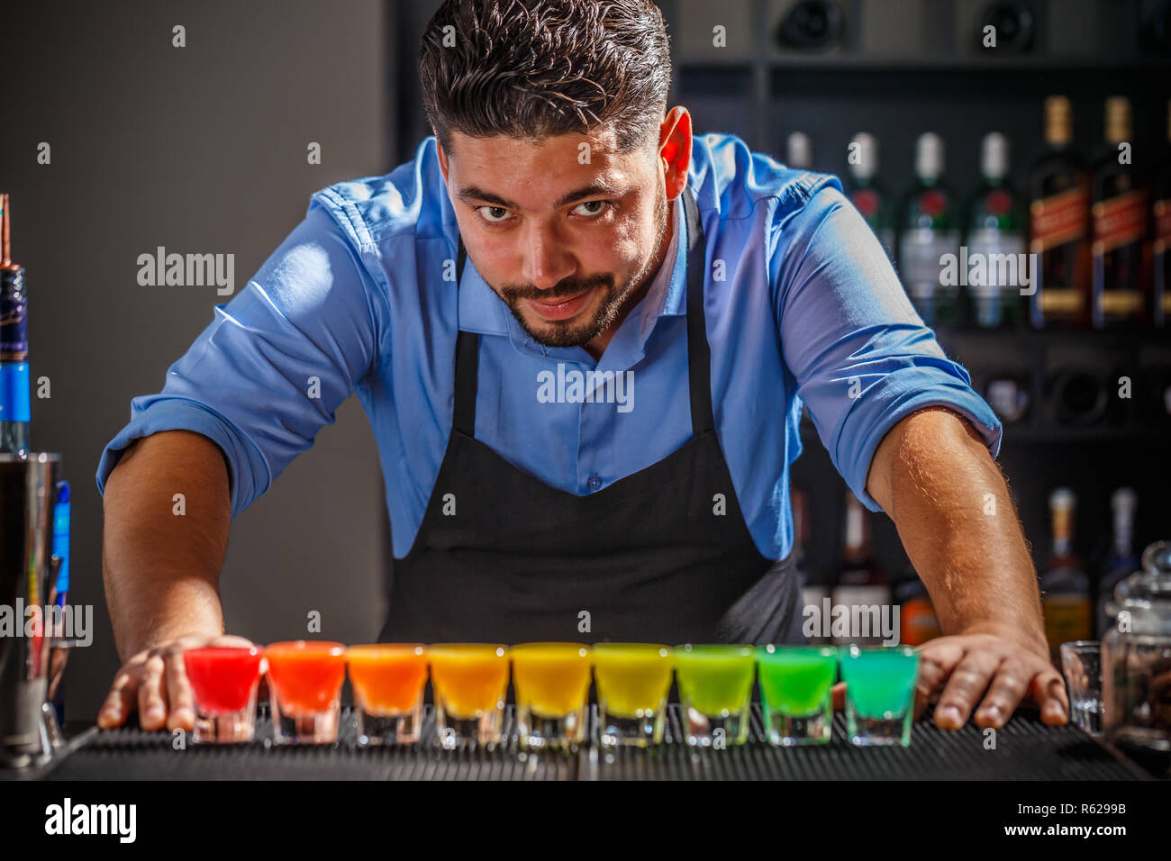 Barman avec rainbow cocktai Banque D'Images