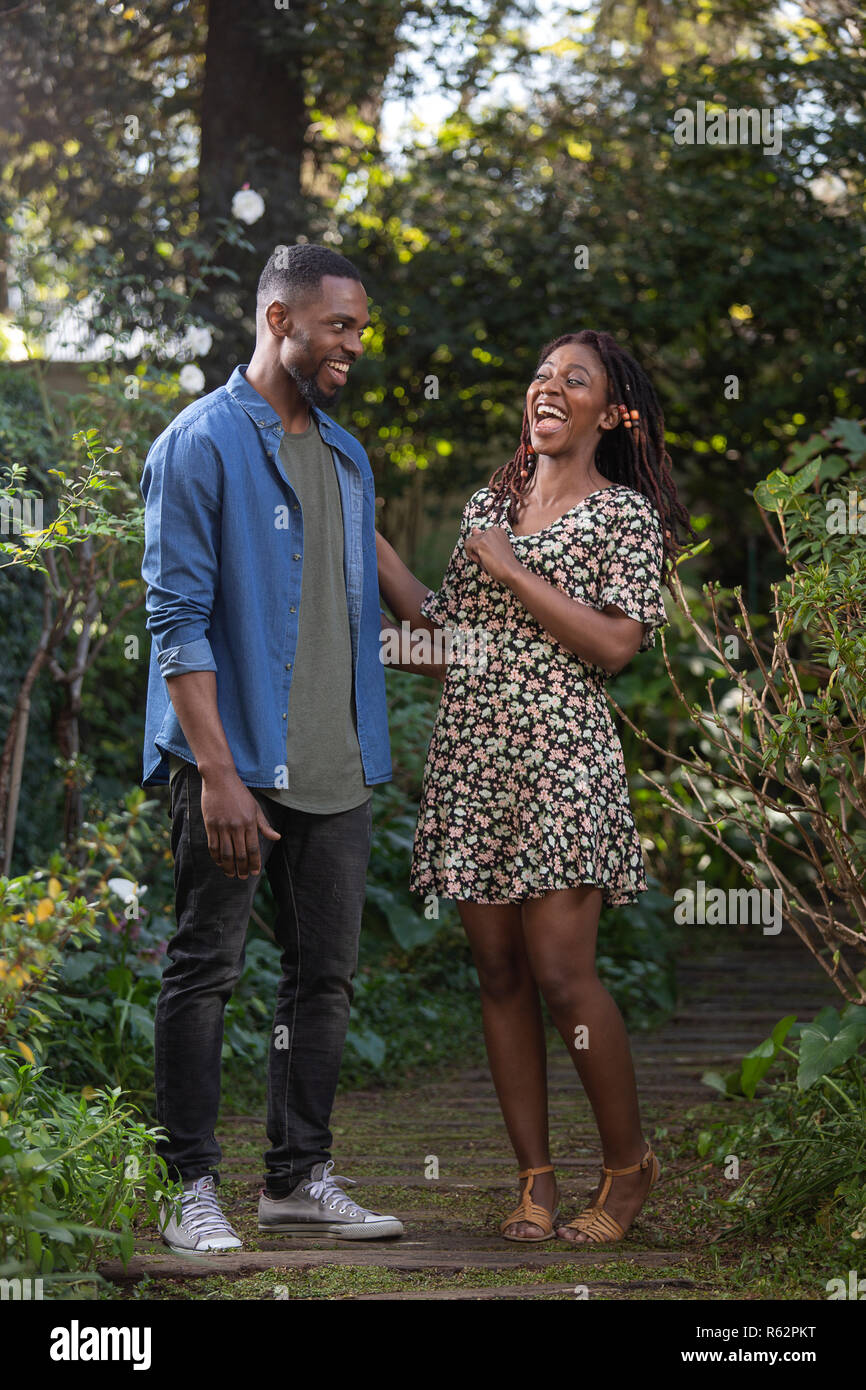 Un couple de rire ensemble dans un jardin Banque D'Images
