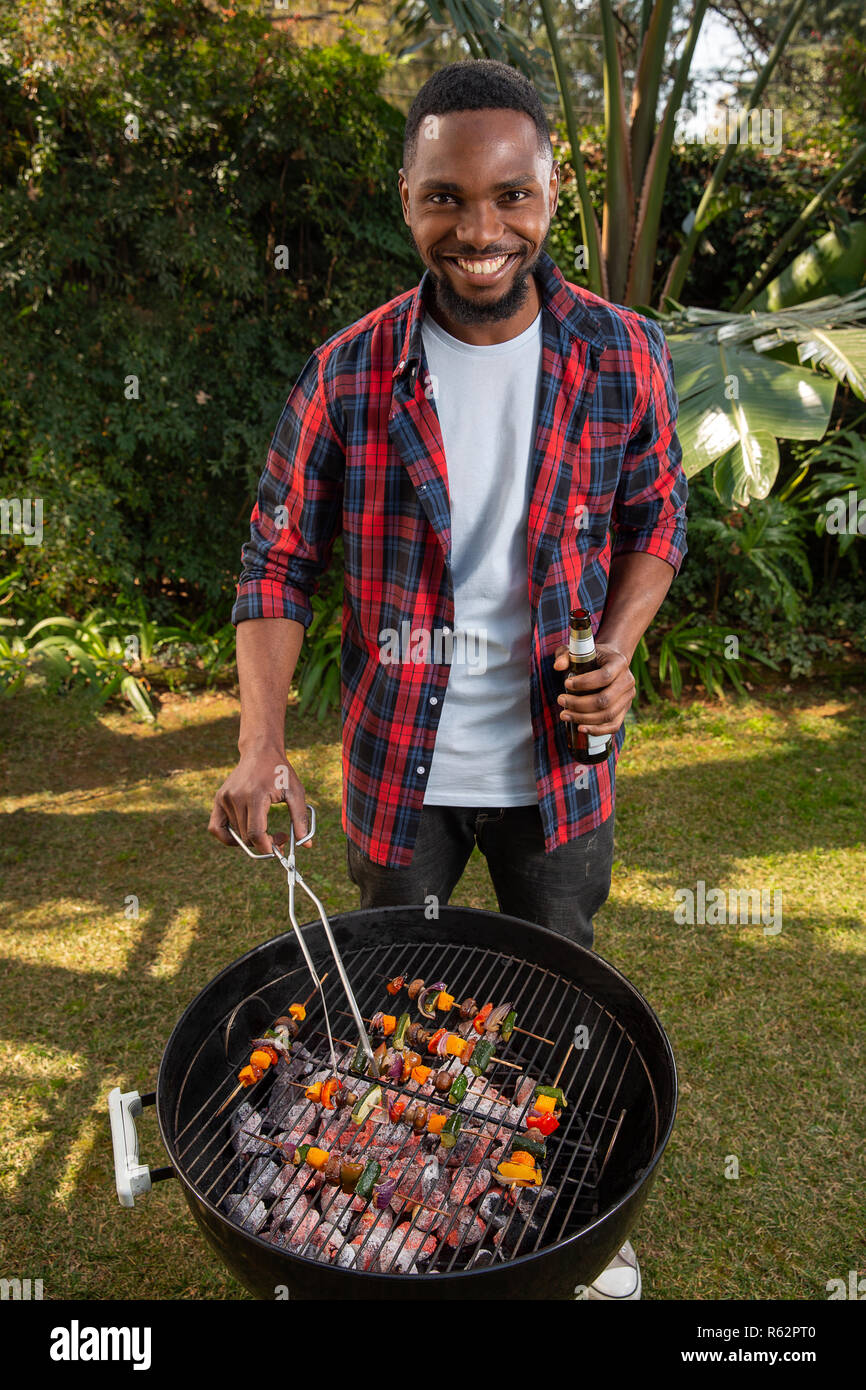 Un homme africain au barbecue Banque D'Images