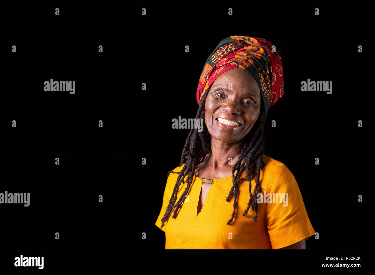 Une vieille femme africaine dans un foulard sur un fond noir Photo Stock -  Alamy
