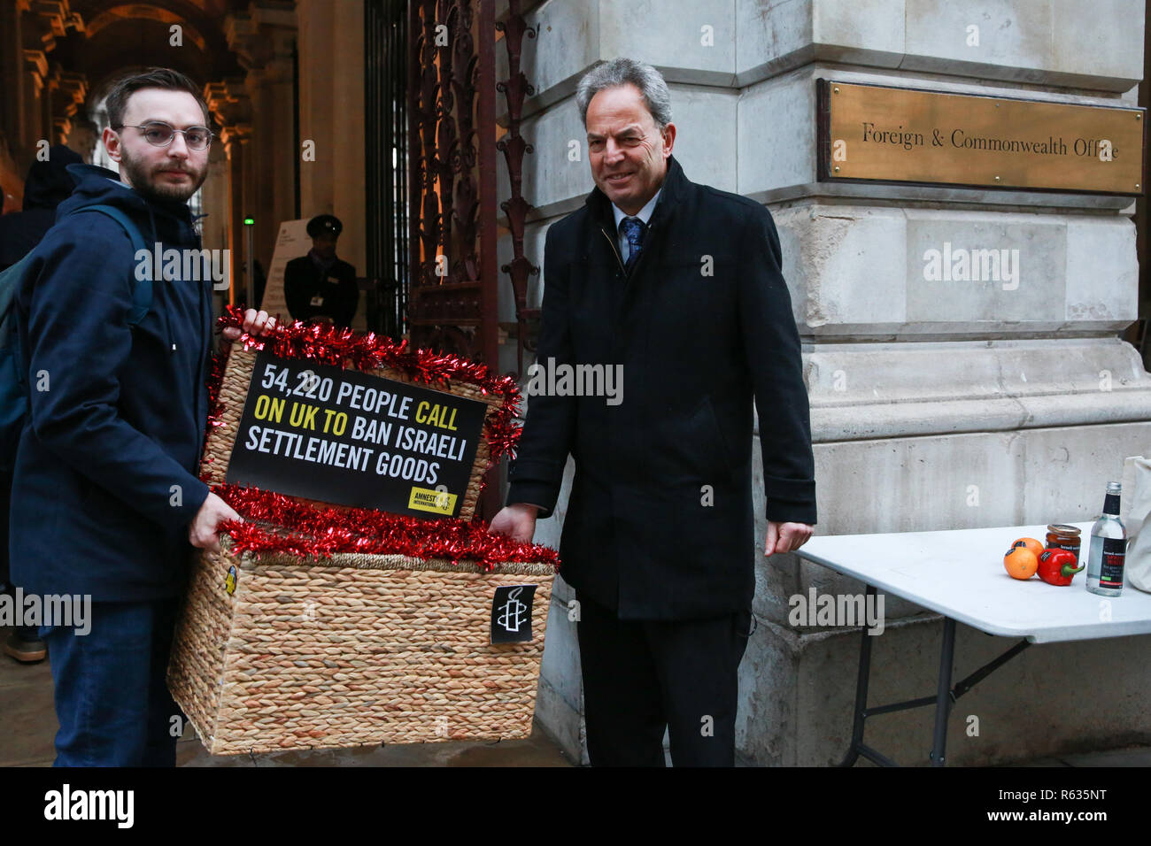 Londres, Royaume-Uni. 3 Décembre, 2018. Les militants d'Amnesty International prendre un "israélien de paniers de Noël de biens volés" y compris le vin rouge, huile d'olive, miel, eau minérale, les œufs, les dates, les poivrons, les oranges et les avocats de l'Office des étrangers afin d'attirer l'attention sur le fait que ces produits sont tous en train d'être produites en Israël's établissements illicites dans les territoires palestiniens de la Cisjordanie et d'appeler les gouvernements partout dans le monde à interdire l'importation de produits des colonies israéliennes. Credit : Mark Kerrison/Alamy Live News Banque D'Images