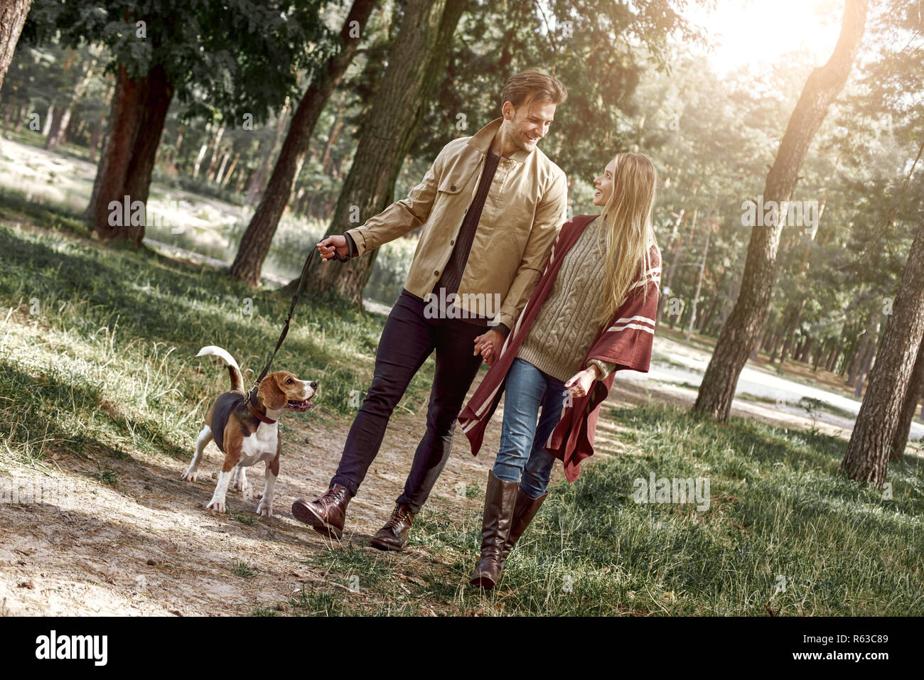 Jeune couple sont walking with dog in forest Banque D'Images