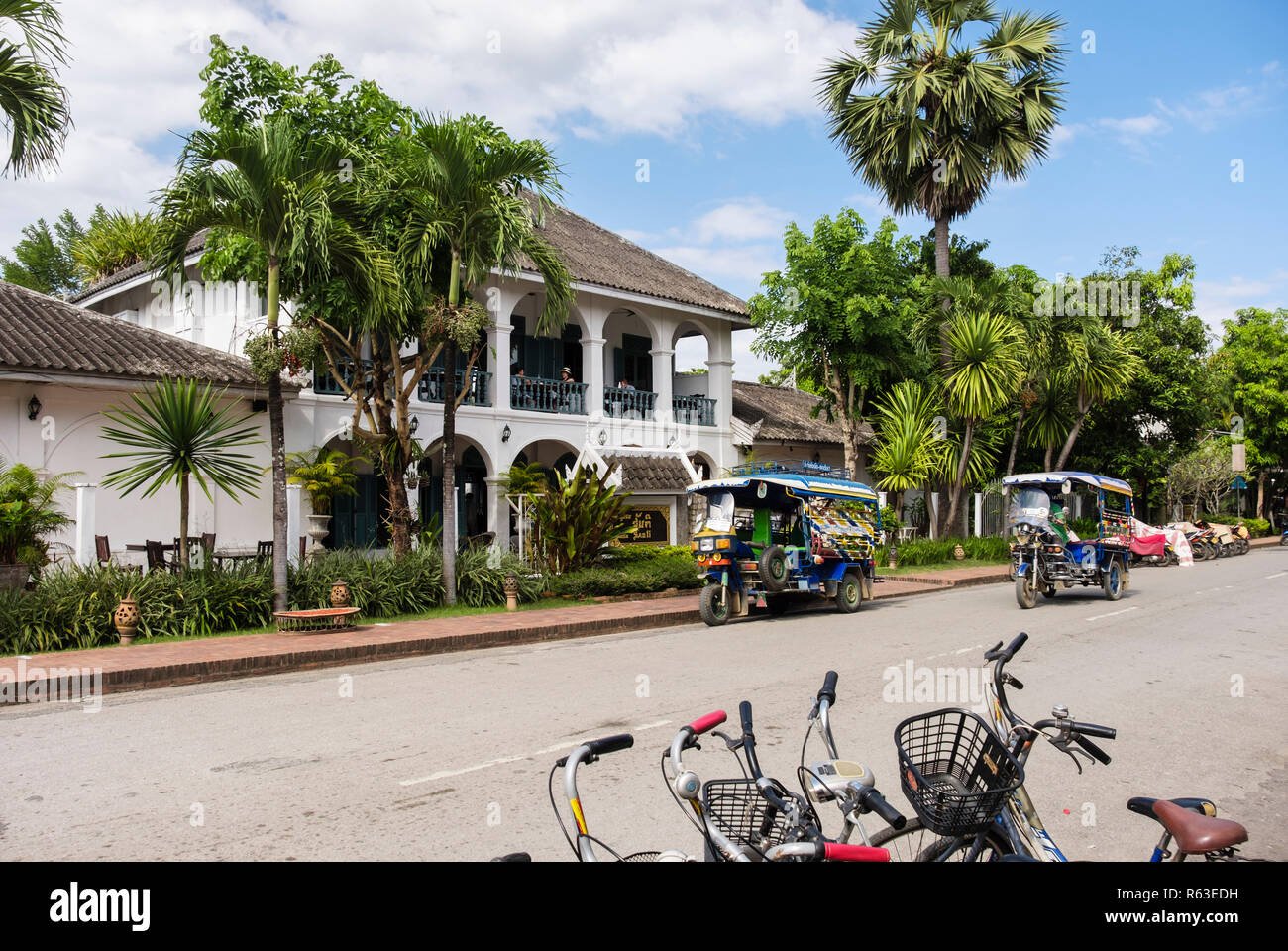 Tuk Tuks dans la rue devant la Villa Santi hotel colonial dans la vieille ville. Sakkaline Road, Luang Prabang, Louangphabang province, Laos, Asie du sud-est Banque D'Images