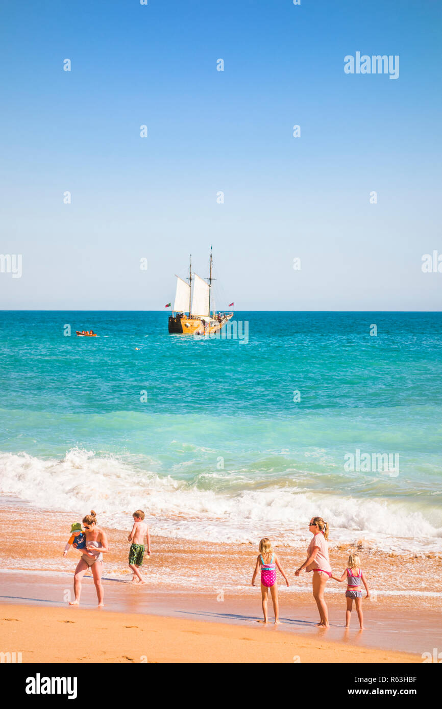 Les familles à benagil plage avec mâts navire tournée sur la côte en arrière-plan Banque D'Images