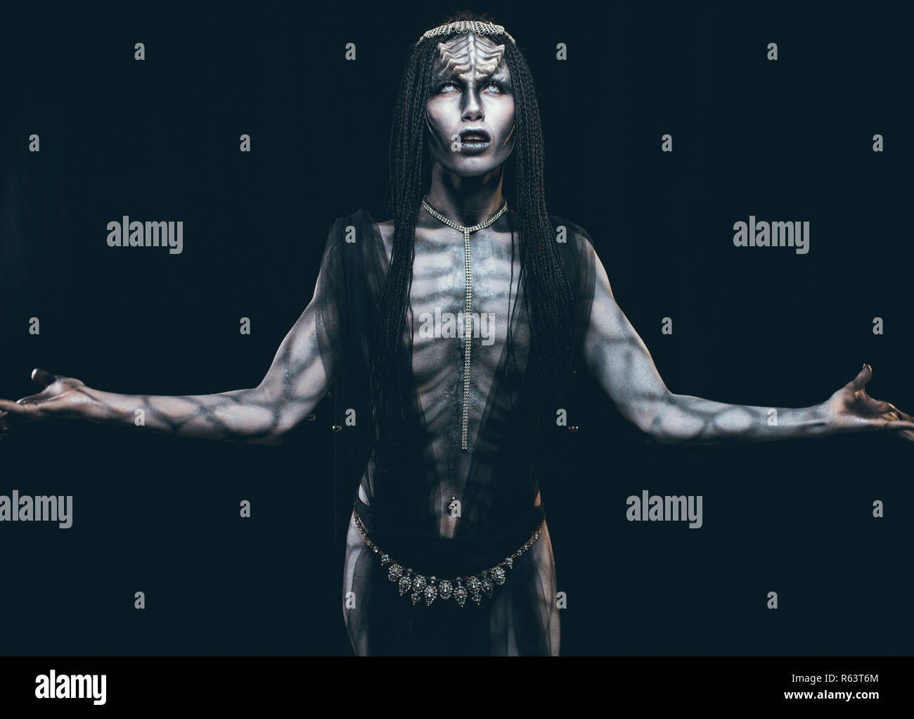 Une jeune femme à l'image d'un alien humanoïde extraterrestre et avec des cornes sur sa tête et un motif sur le corps comme un reptile. Banque D'Images